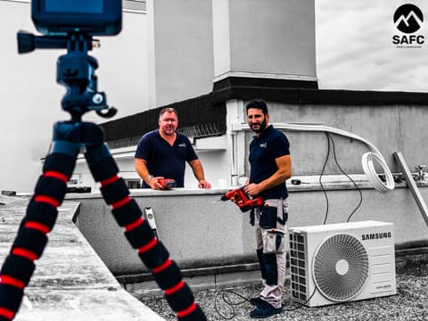 photo d'une équipe de société de climatisation entrain d'installer le groupe exterieur d'un split samsung freewind